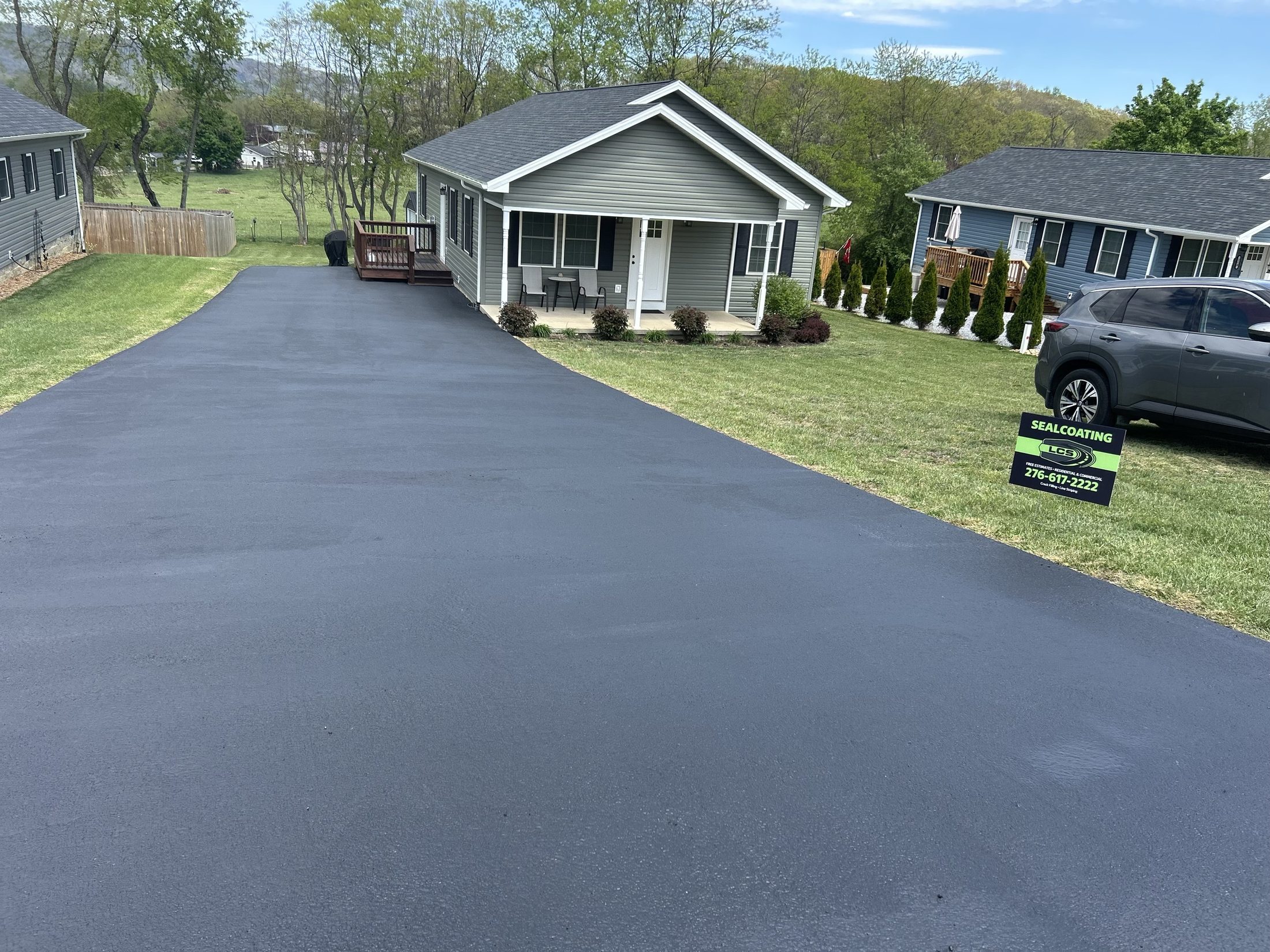 LCS Striping yard sign beside a freshly sealcoated driveway