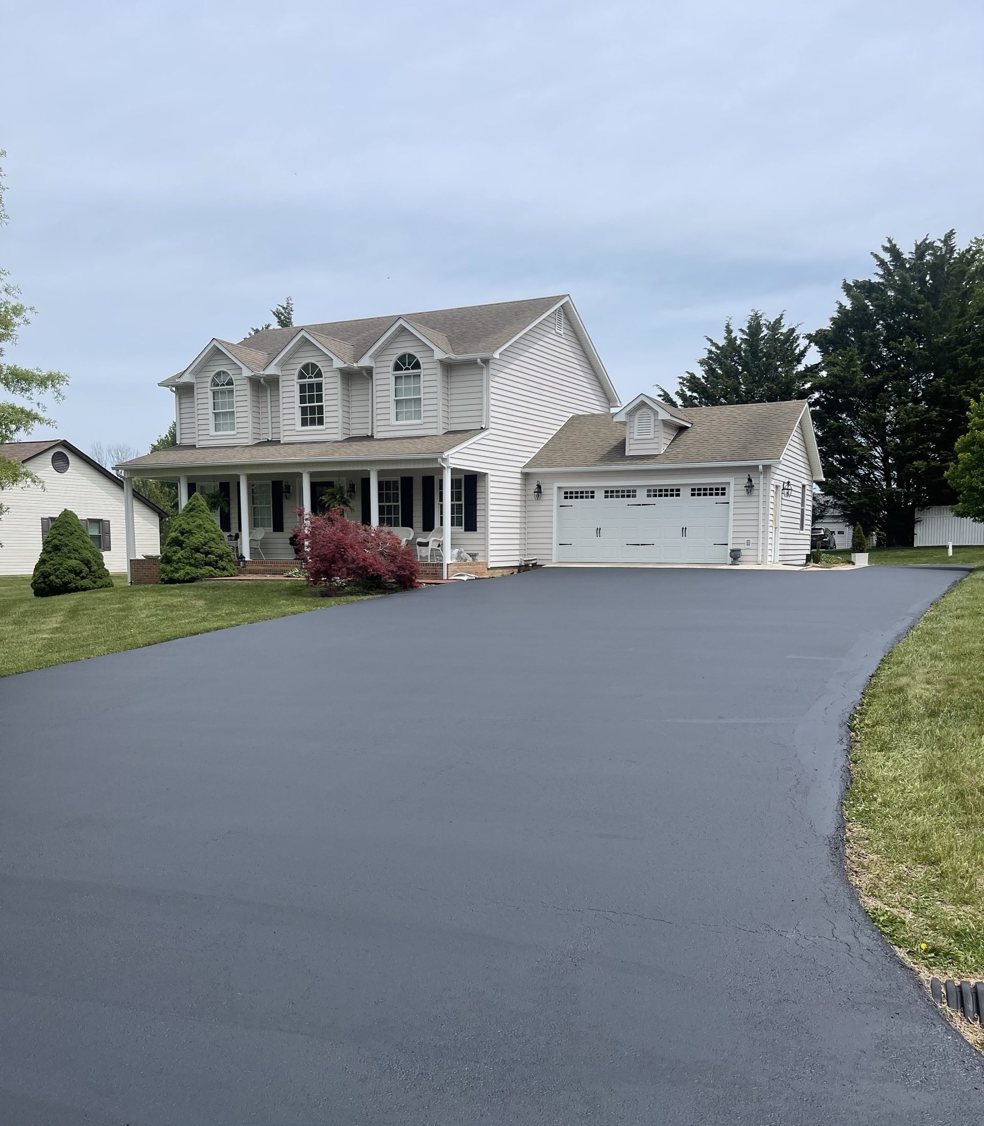 Large home with a wide freshly sealed driveway