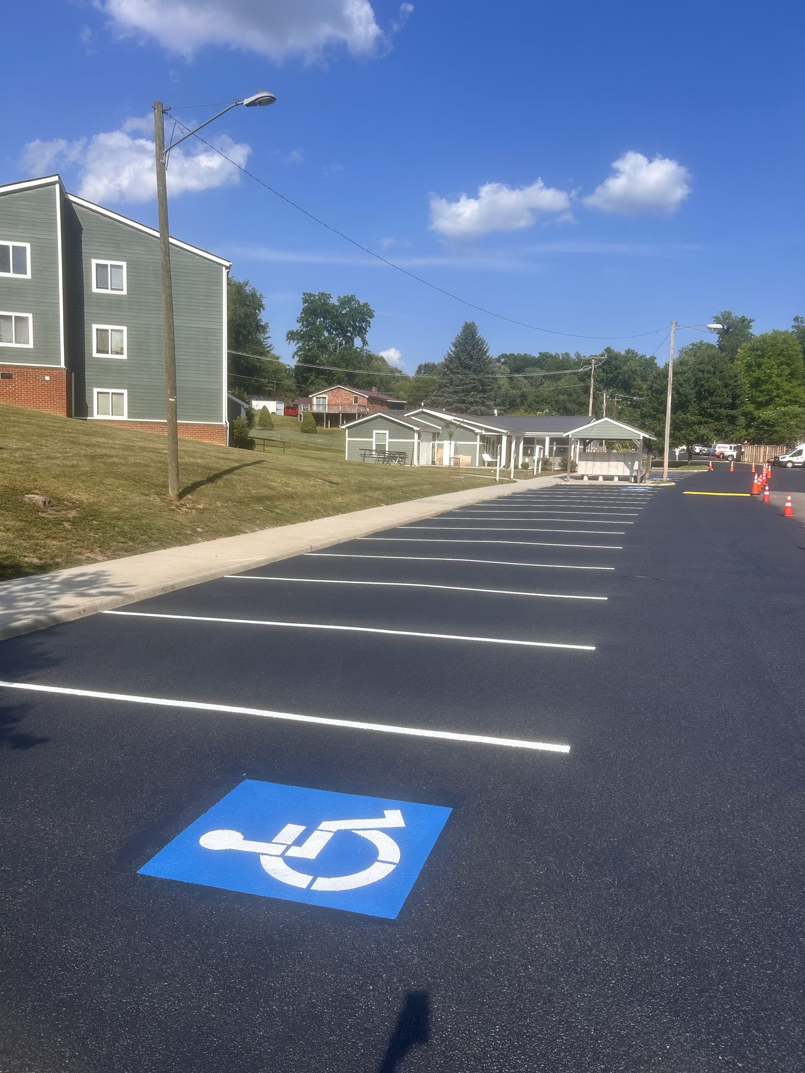 Deep-black apartment parking lot with crisp white striping